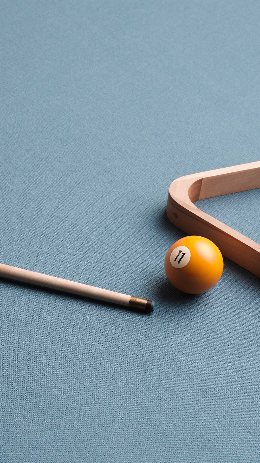 Pool ball with number 11 and pool cue on a blue table