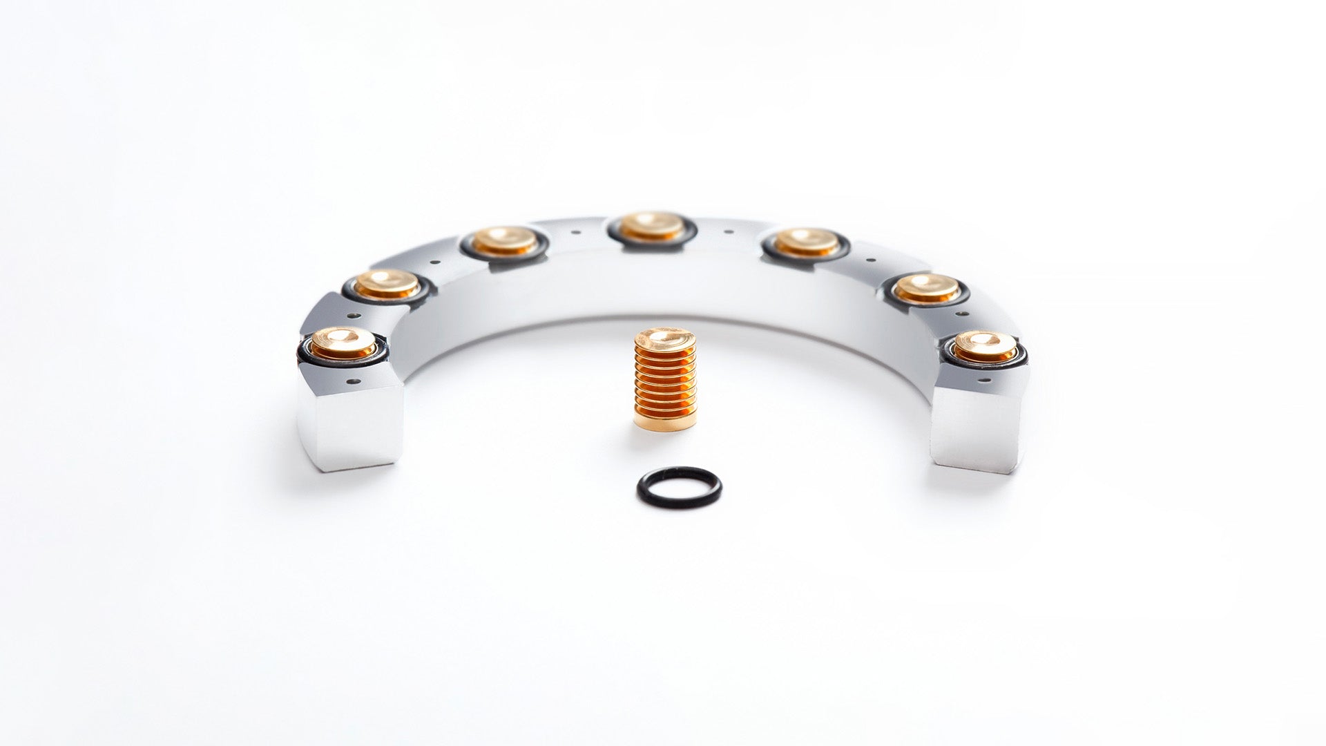 Ressence watches mechanical bellows used on oil-filled watches to compensate for oil volume fluctuation in the upper part of the dial, with gold and silver parts on a white background