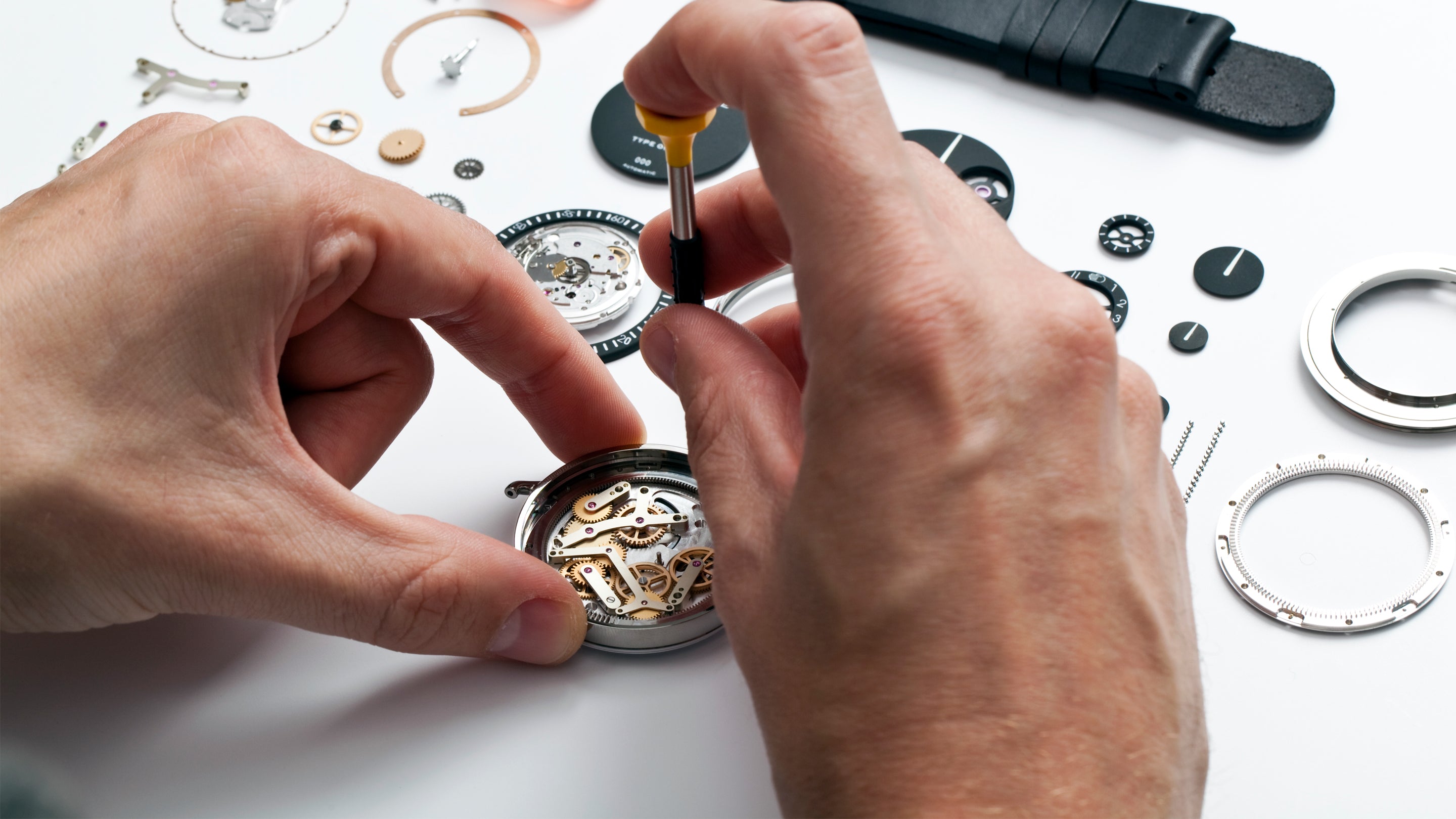 Watchmaker working with a precision screwdriver on a Ressence ROCS (Ressence Orbital Convex System) module during a standard after sales service