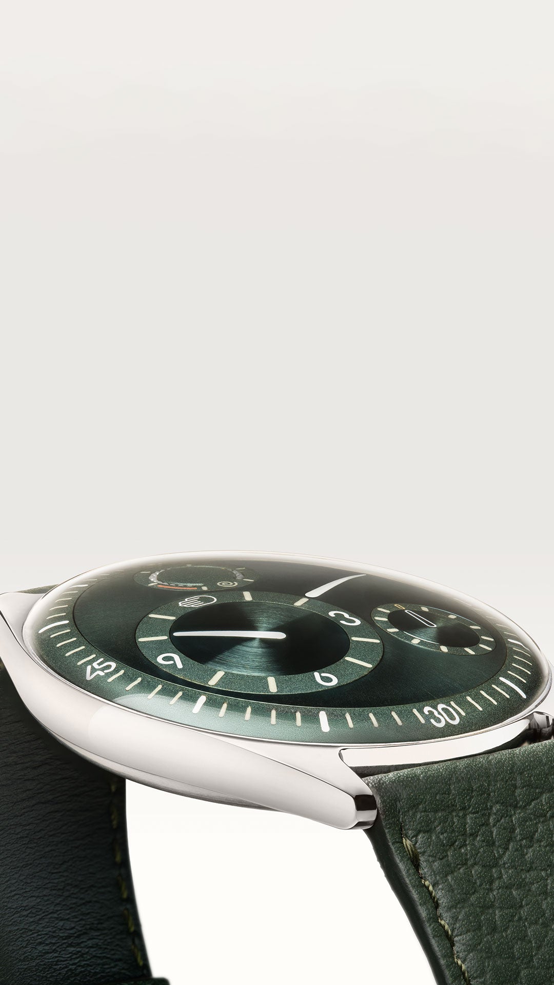 Vertical image of a Ressence TYPE 11 Pine, a contemporary luxury watch with green face and leather strap on a white background