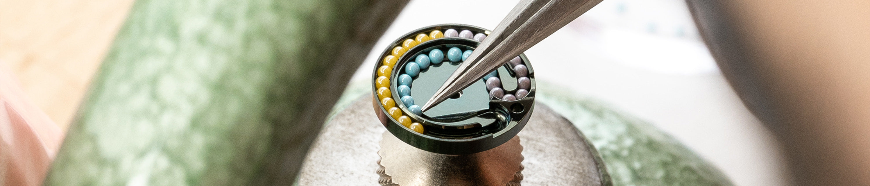 Close-up of a the Ressence TYPE 11 power reserve indication mechanical component being worked on with tweezers.