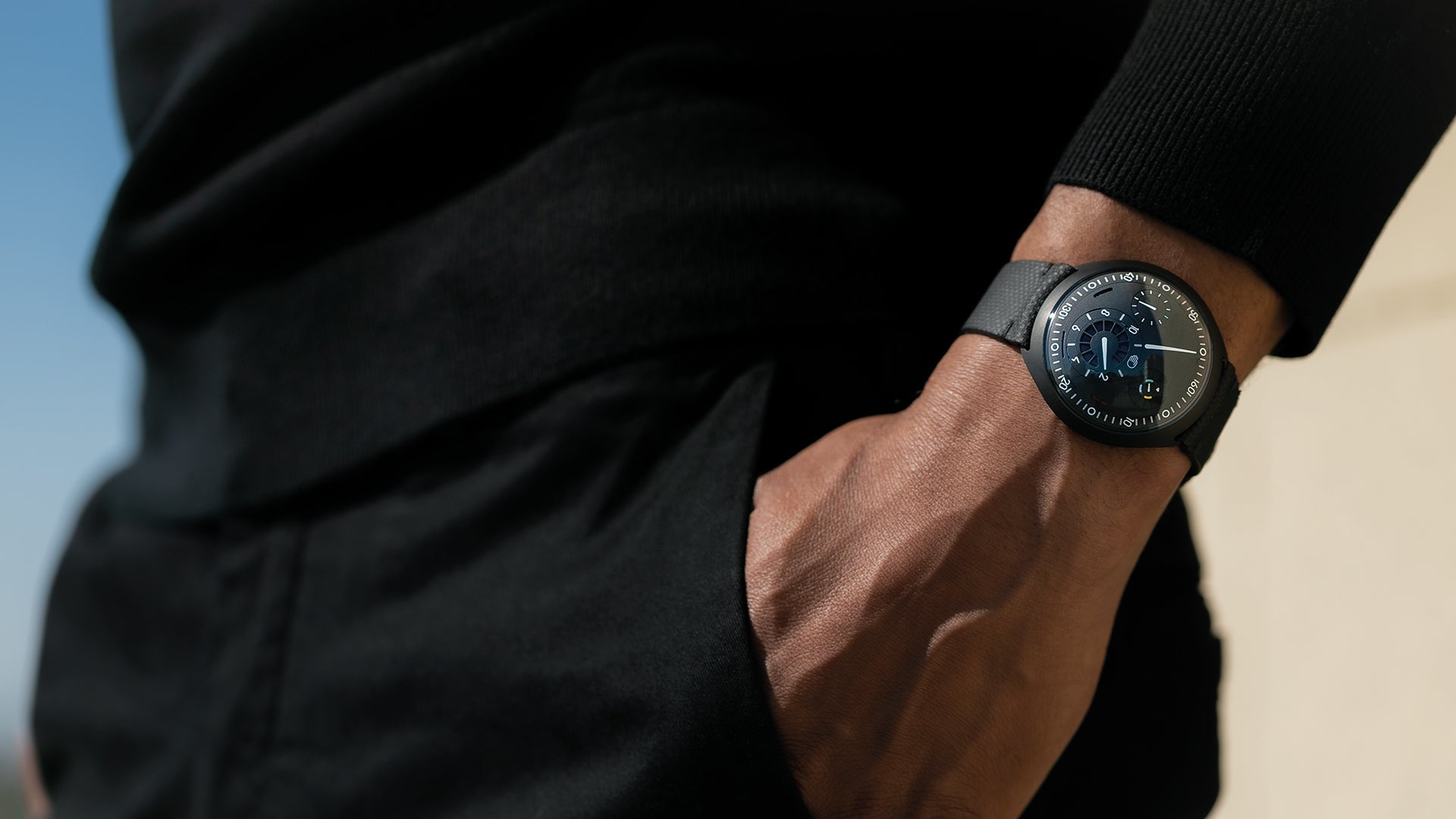 Person wearing a Ressence TYPE 1 Anthracite innovative dual time-zone watch with their hand in the pocket me-zone 