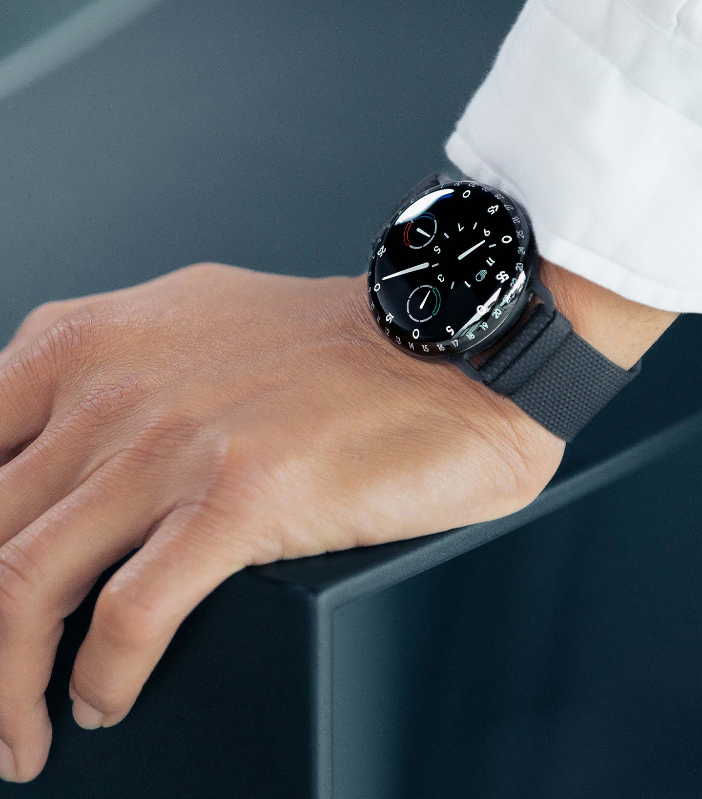 Ressence TYPE 3 BB2, the high end oil-filled mechanical watch, shown on a man's wrist with a white shirt. vertical image.