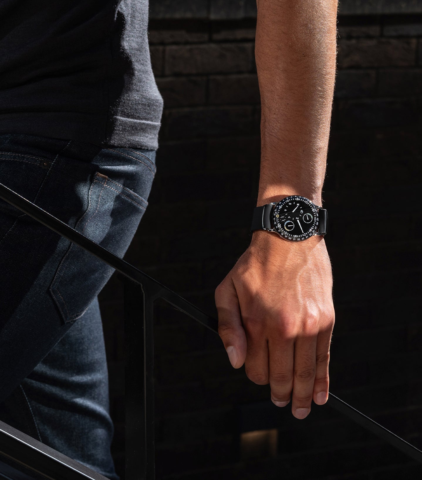 Vertical image of a person wearing the oil-filled Ressence TYPE 3 while talking up stairs The TYPE 3 is Ressence’s iconic watch, winner of multiple competitions such as the GPHG and the Red Dot Best of the Best award.