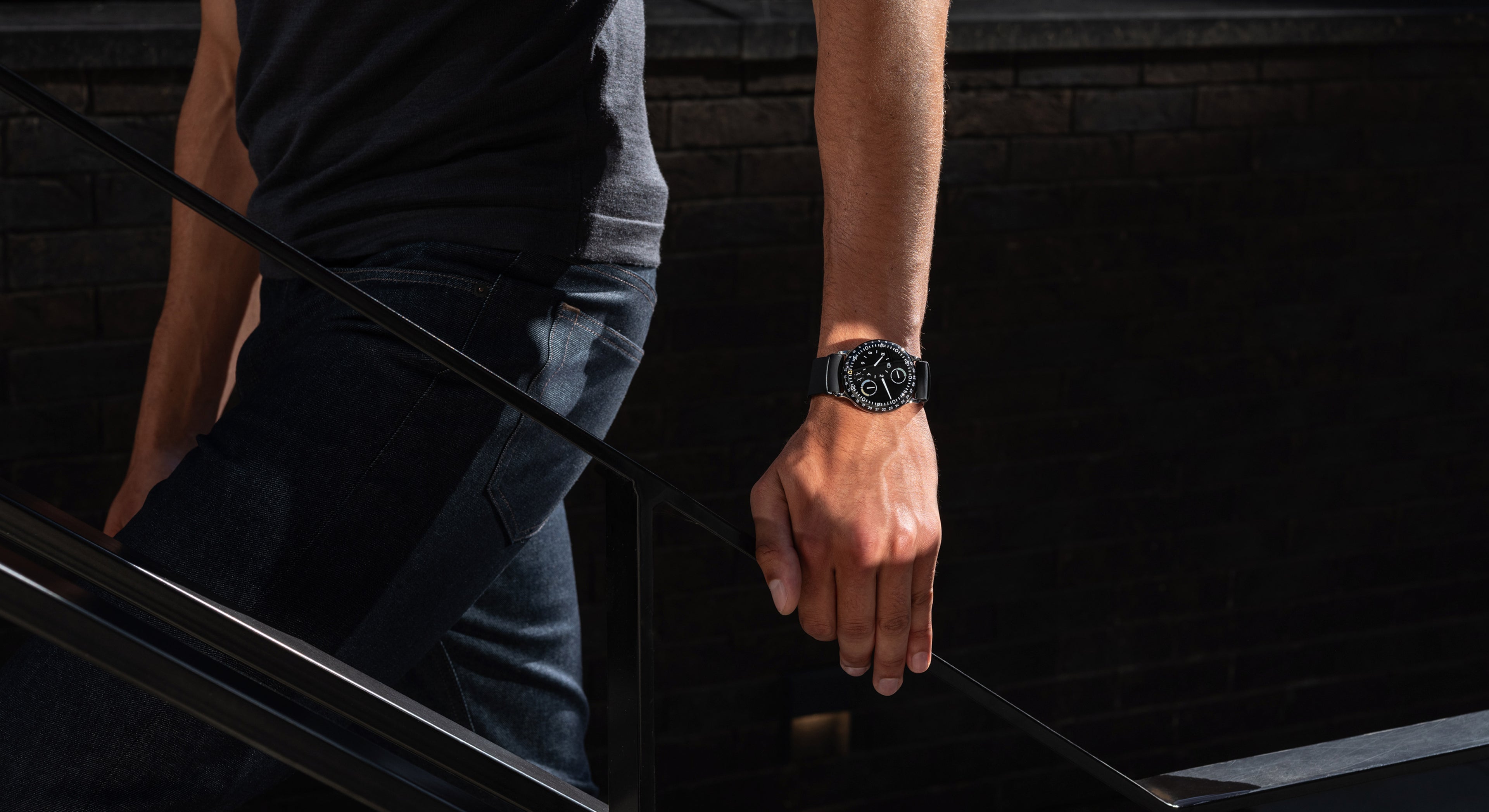 Person wearing the oil-filled Ressence TYPE with a black dial while walking up stairs. The TYPE 3 is Ressence’s iconic watch, winner of multiple competitions such as the GPHG and the Red Dot Best of the Best award.