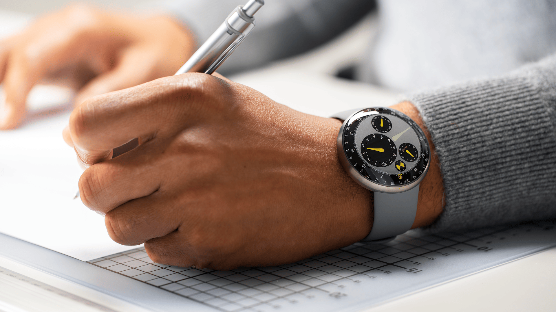 Person wearing the limited edition oil-filled Ressence TYPE 3 Marc Newson while writing on paper. The TYPE 3 is Ressence’s iconic watch, winner of multiple competitions such as the GPHG and the Red Dot Best of the Best award.