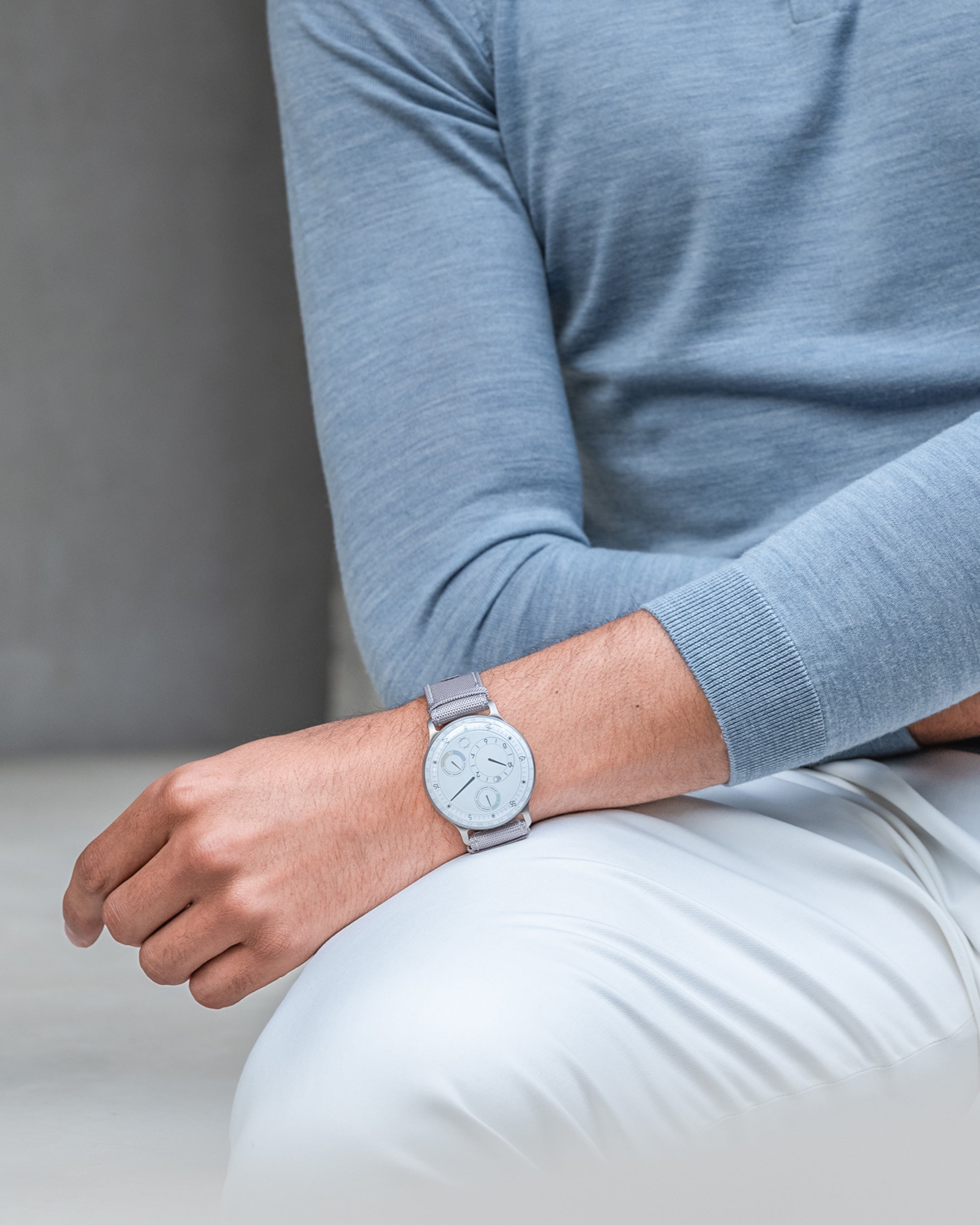 Vertical image of a man sitting wearing a Ressence TYPE 3 White, the ultimate oil-filled high end mechanical watch