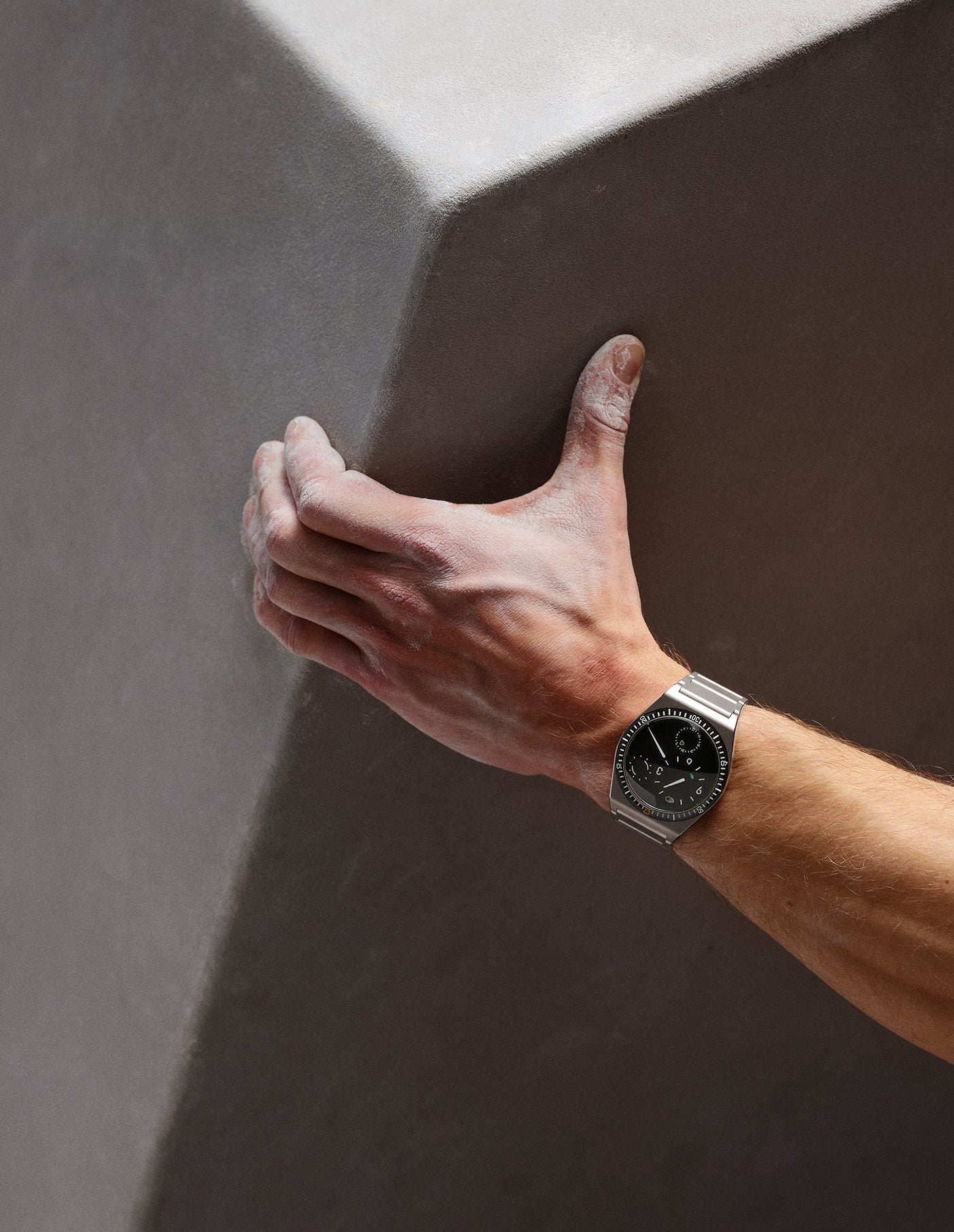 Ressence TYPE 7 Black, a titanium GMT watch, shown on a man's wrist. Vertical image
