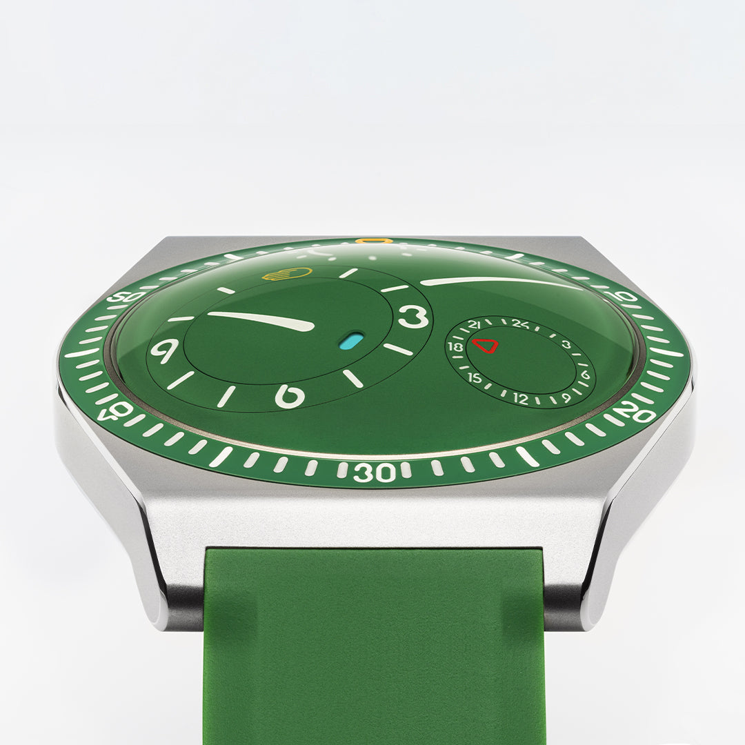 Square image of a cactus green Ressence TYPE 7 titanium GMT sport-chic watch shown dial up, with a green rubber strap on a white background