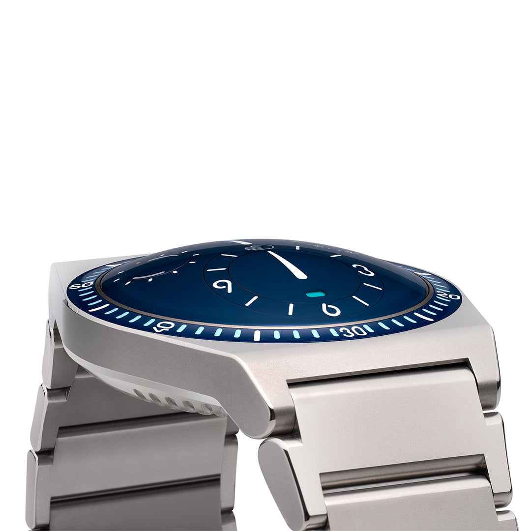 Close-up of a night blue Ressence TYPE 7 sport-chic GMT watch with a titanium integrated bracelet, shown dial up.
